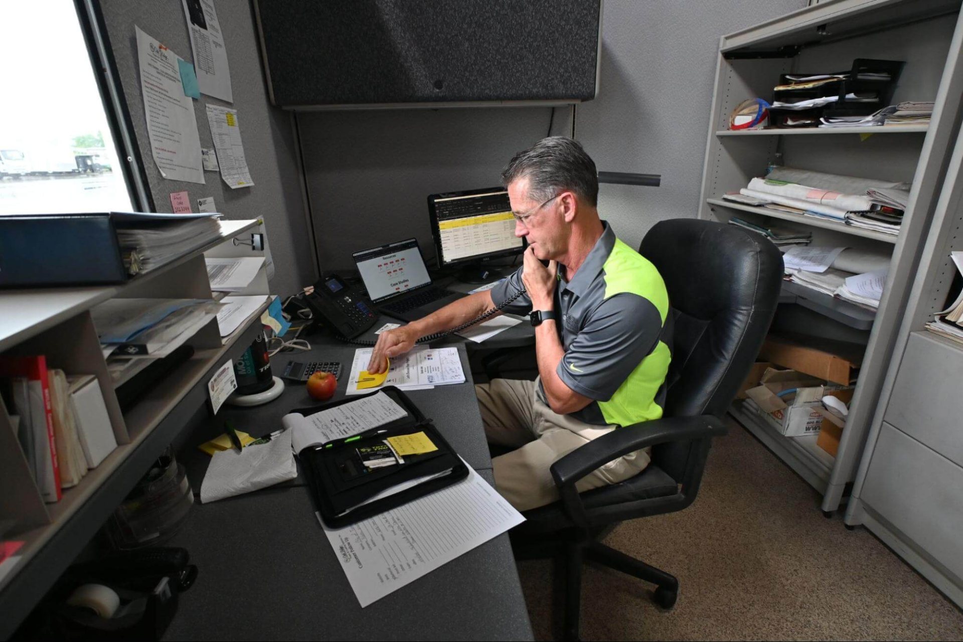 Oak Ridge employee sits in Wisconsin office. He's chatting with a foam insulation customer and taking an order.